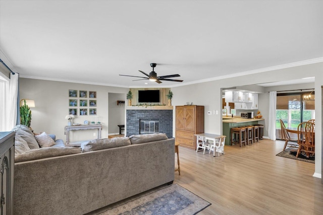 415 E 14th St, Gibson City, IL 60936 - living room with light wood finished floors, baseboards, a glass covered fireplace, ceiling fan, and ornamental molding