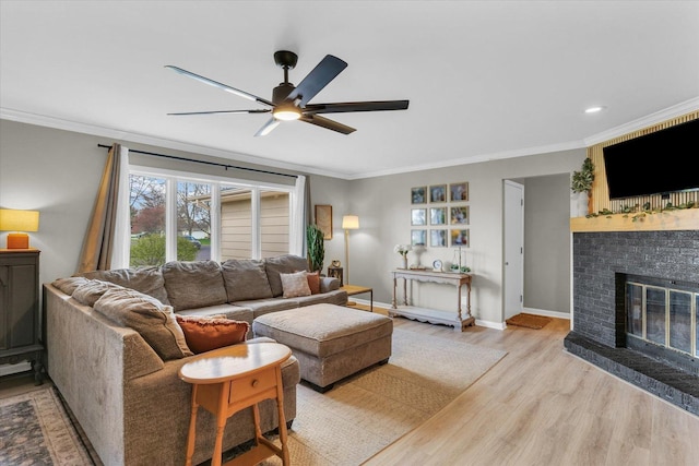 415 E 14th St, Gibson City, IL 60936 - living room featuring a ceiling fan, crown molding, light wood finished floors, baseboards, and a brick fireplace