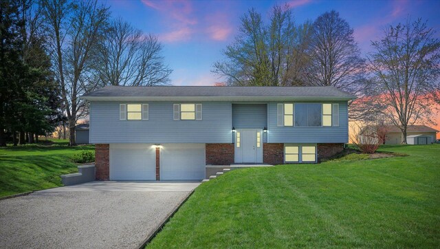 2 Woodland Dr, White Heath, IL 61884 - bi-level home with asphalt driveway, a garage, a yard, and brick siding