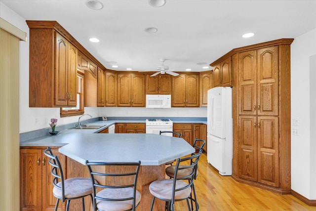2 Woodland Dr, White Heath, IL 61884 - kitchen with white appliances, a sink, a breakfast bar area, a peninsula, and a ceiling fan