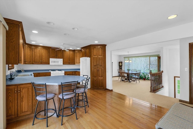 2 Woodland Dr, White Heath, IL 61884 - kitchen featuring white appliances, a sink, recessed lighting, a peninsula, and light wood-style floors