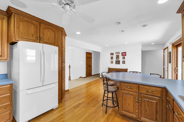 2 Woodland Dr, White Heath, IL 61884 - kitchen featuring freestanding refrigerator, a ceiling fan, light wood-style flooring, brown cabinetry, and recessed lighting