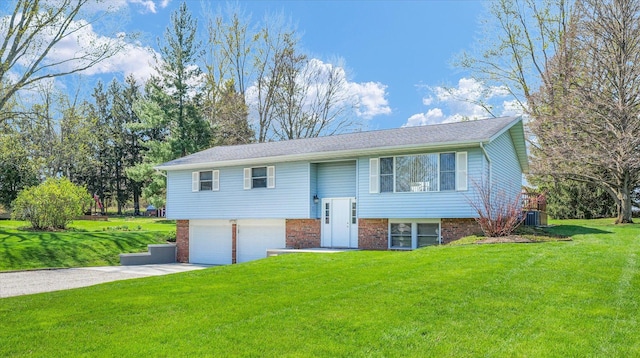 2 Woodland Dr, White Heath, IL 61884 - bi-level home featuring concrete driveway, a garage, a front lawn, and brick siding