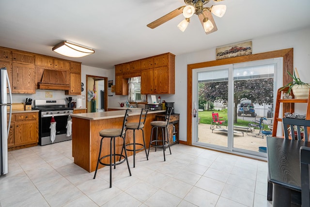 918 Dawes Ave, Joliet, IL 60435 - kitchen with appliances with stainless steel finishes, premium range hood, brown cabinetry, a peninsula, and light countertops