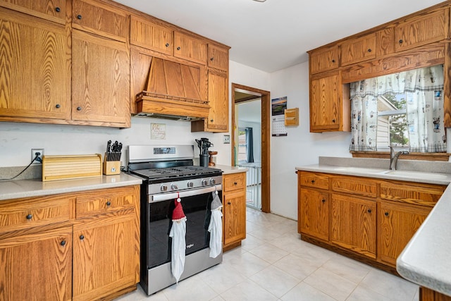 918 Dawes Ave, Joliet, IL 60435 - kitchen with gas stove, custom range hood, a sink, light countertops, and brown cabinets