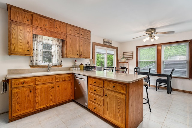 918 Dawes Ave, Joliet, IL 60435 - kitchen with stainless steel dishwasher, a peninsula, brown cabinets, and light countertops