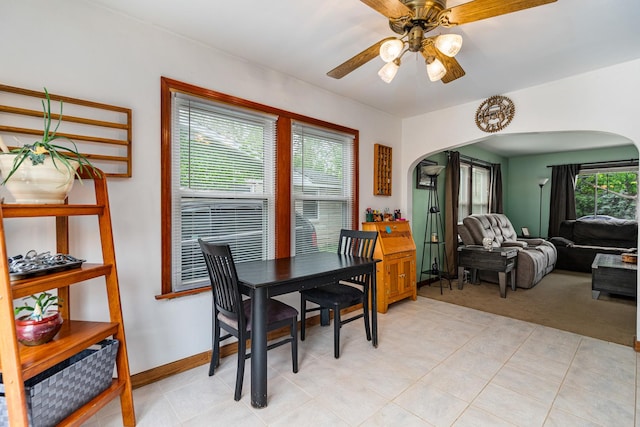 918 Dawes Ave, Joliet, IL 60435 - dining room with arched walkways, a ceiling fan, light carpet, and baseboards