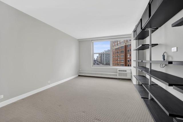empty room with radiator heating unit, baseboards, a wall mounted air conditioner, and carpet
