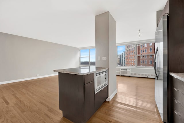 kitchen featuring dark brown cabinetry, light wood-style floors, modern cabinets, and appliances with stainless steel finishes