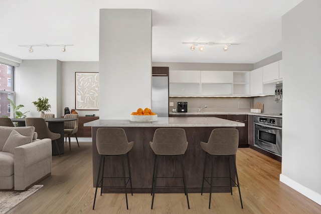 kitchen with track lighting, modern cabinets, white cabinets, and stainless steel appliances