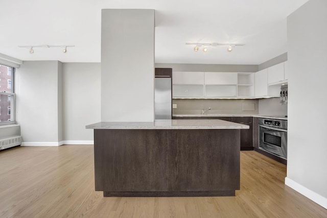kitchen with rail lighting, open shelves, white cabinets, modern cabinets, and stainless steel appliances
