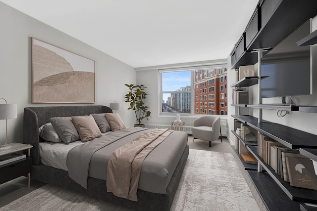 bedroom with wood finished floors and radiator heating unit