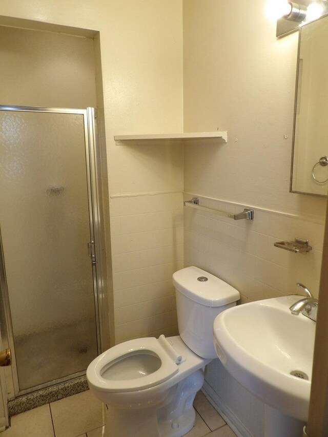 16315 Kenwood Ave, South Holland, IL 60473 - bathroom featuring a stall shower, toilet, tile patterned flooring, and a sink