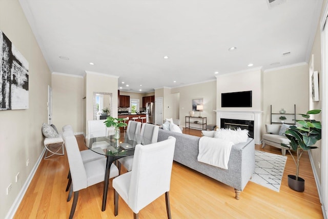 3443 N Lincoln Ave Unit 4A, Chicago, IL 60657 - dining area with light wood-type flooring, recessed lighting, baseboards, a glass covered fireplace, and crown molding