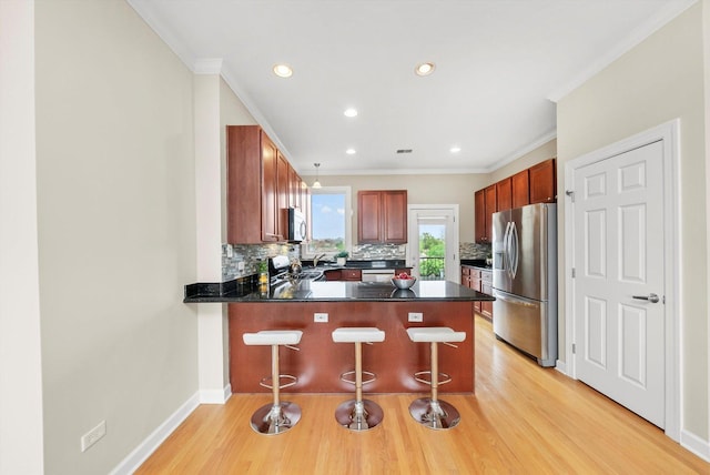 3443 N Lincoln Ave Unit 4A, Chicago, IL 60657 - kitchen with stainless steel appliances, tasteful backsplash, a peninsula, dark countertops, and crown molding