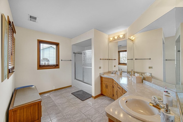 bathroom featuring baseboards, vanity, visible vents, and plenty of natural light