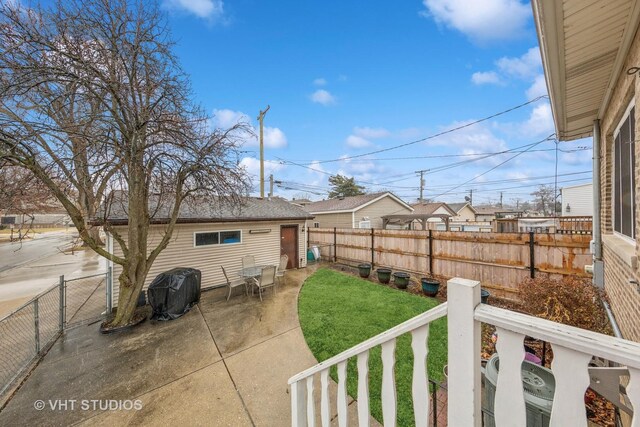 view of yard with a patio, a fenced backyard, and an outdoor structure