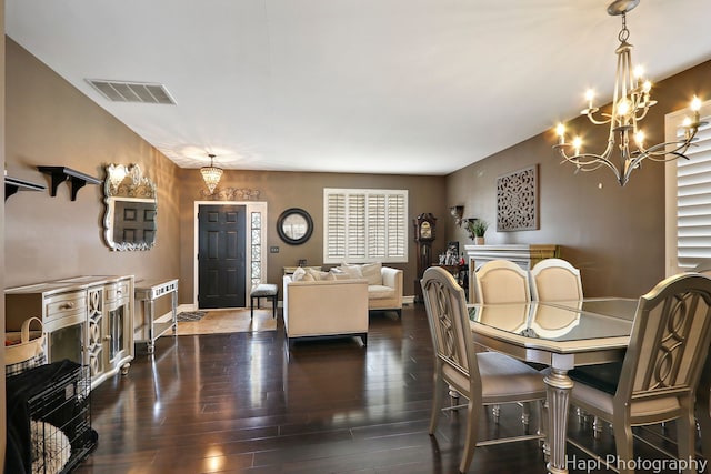 dining space with baseboards, a notable chandelier, visible vents, and hardwood / wood-style flooring