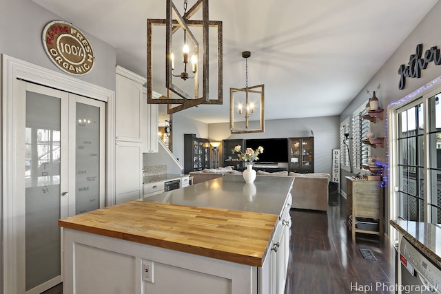 kitchen featuring wooden counters, white cabinetry, and a notable chandelier