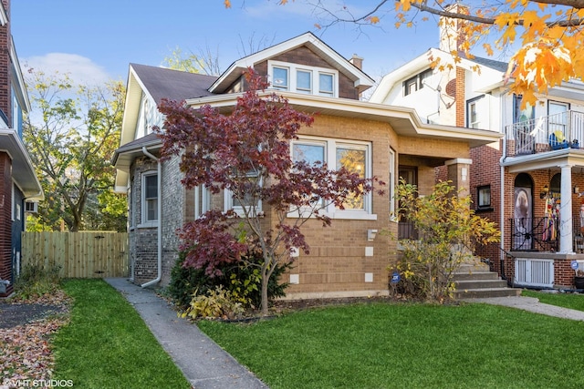 view of front of property with brick siding, a front yard, and fence