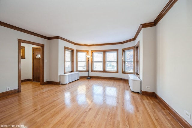 unfurnished living room featuring crown molding, radiator heating unit, light wood finished floors, and baseboards