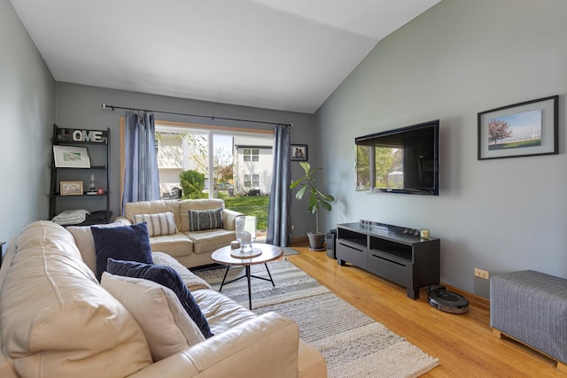 living room with light wood-style floors, plenty of natural light, lofted ceiling, and baseboards