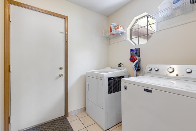laundry area with washer and dryer and light tile patterned flooring