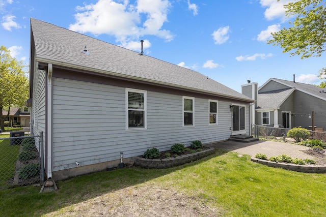 rear view of property featuring roof with shingles and entry steps
