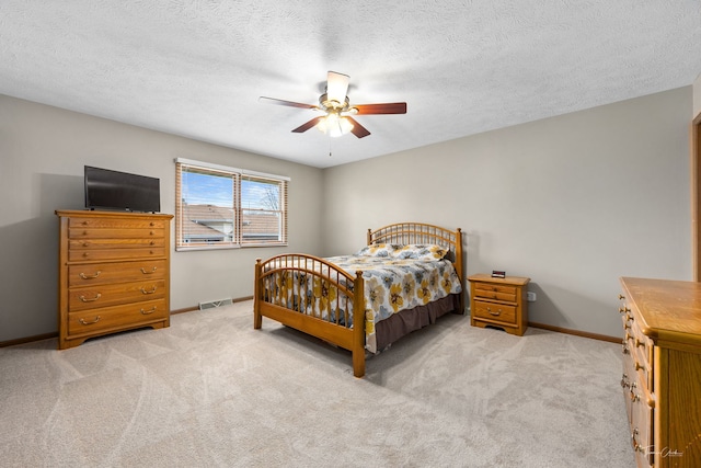 bedroom with ceiling fan, visible vents, baseboards, and light carpet
