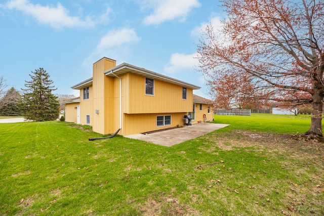 rear view of property with fence, a patio area, and a yard