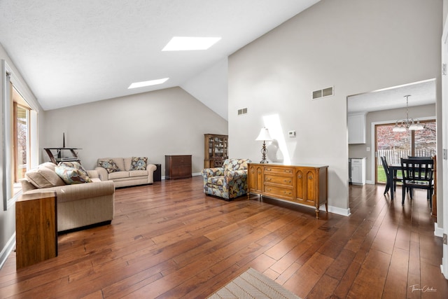 living area featuring dark wood-type flooring, a chandelier, visible vents, and a skylight