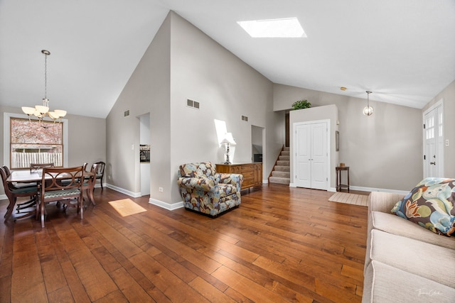 living area with dark wood-style floors, visible vents, an inviting chandelier, stairs, and high vaulted ceiling