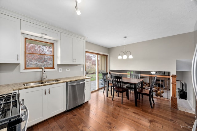 kitchen with white cabinets, dishwasher, a sink, gas stove, and a chandelier
