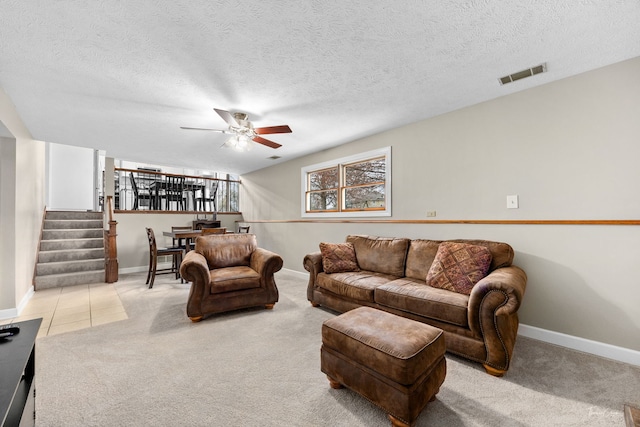 living area with carpet floors, a ceiling fan, visible vents, and baseboards