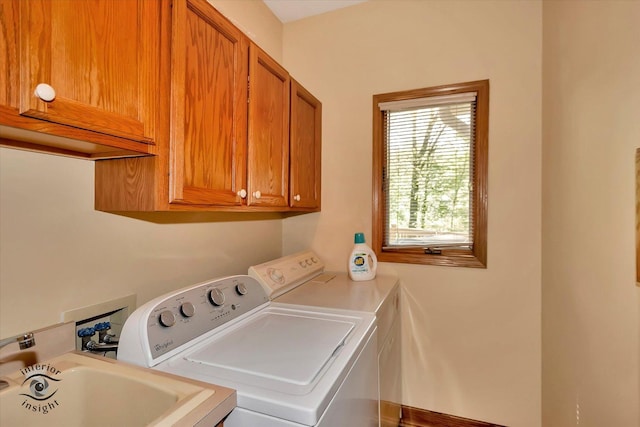 clothes washing area featuring separate washer and dryer and cabinet space