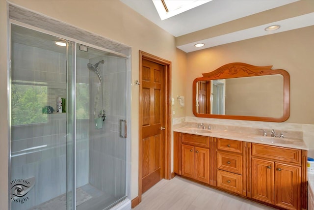 full bath featuring a skylight, a stall shower, and double vanity