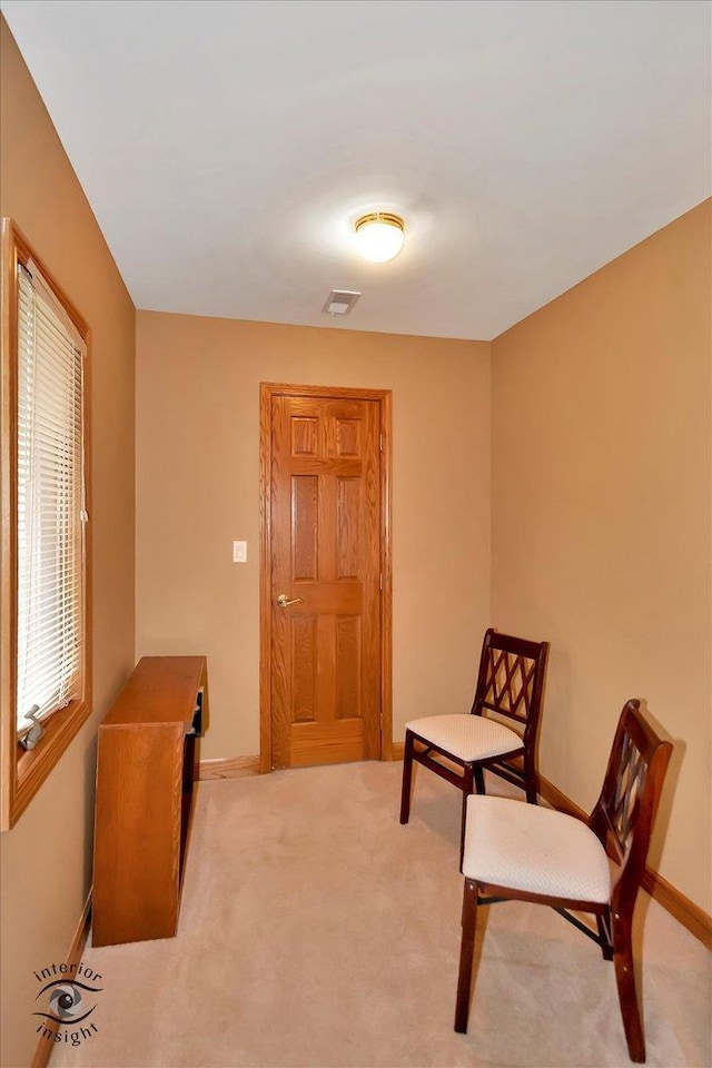 living area featuring carpet flooring and baseboards