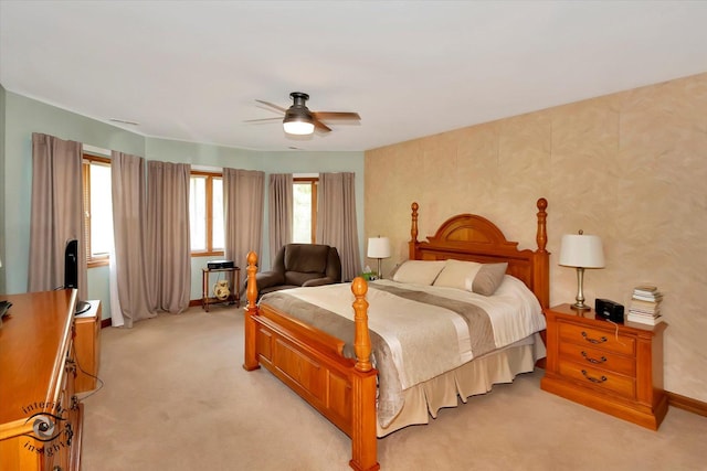 bedroom featuring light carpet, ceiling fan, and baseboards