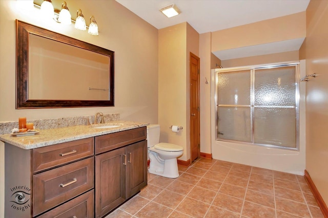 full bath with baseboards, toilet, vanity, tile patterned floors, and bath / shower combo with glass door
