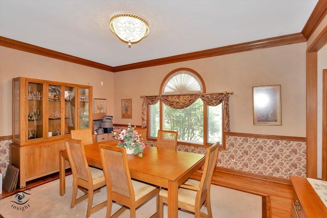dining space with light wood-style flooring, ornamental molding, a chandelier, baseboards, and wallpapered walls