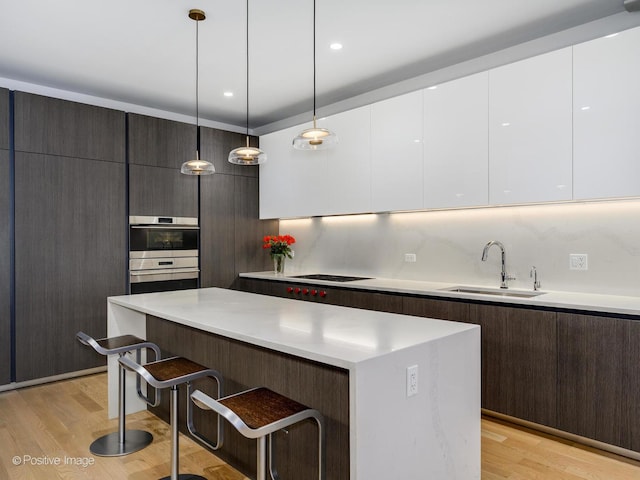 2035 N Orleans St Unit 2N, Chicago, IL 60614 - kitchen featuring cooktop, a sink, modern cabinets, and a breakfast bar