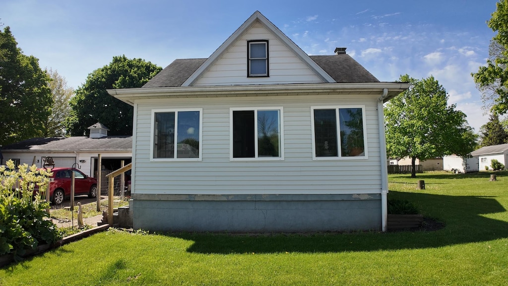 1408 E Washington St, Clinton, IL 61727 - rear view of house featuring roof with shingles and a yard