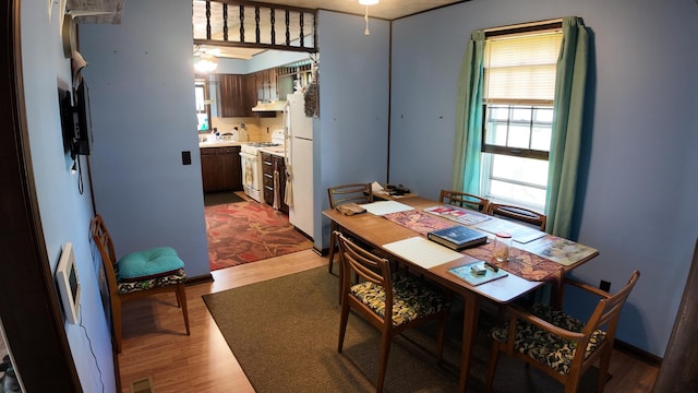 dining area with a ceiling fan, wood finished floors, and visible vents