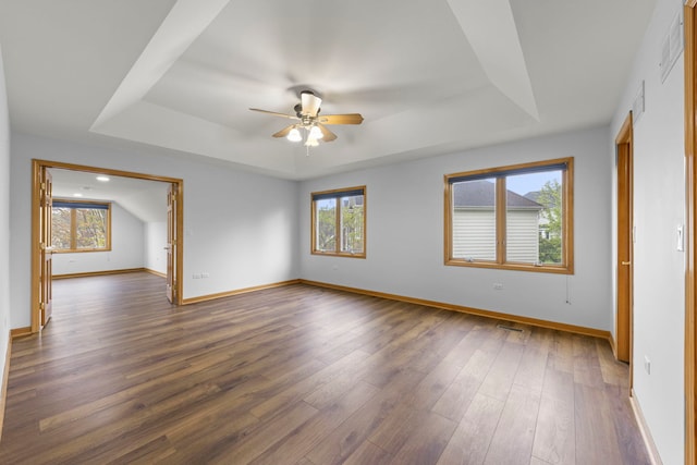 empty room featuring a raised ceiling, a wealth of natural light, and a ceiling fan