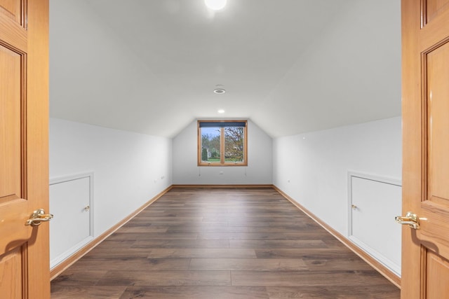 additional living space with lofted ceiling, dark wood-style flooring, and baseboards