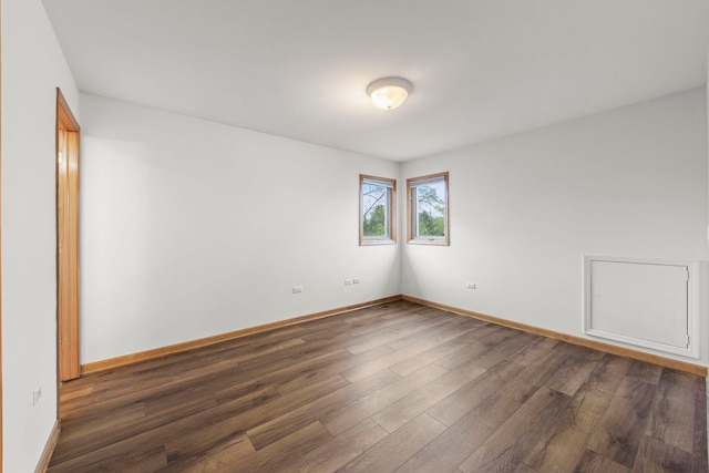 unfurnished room featuring dark wood-style flooring and baseboards