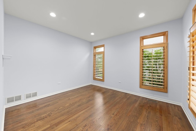 unfurnished room featuring dark wood-style flooring and visible vents