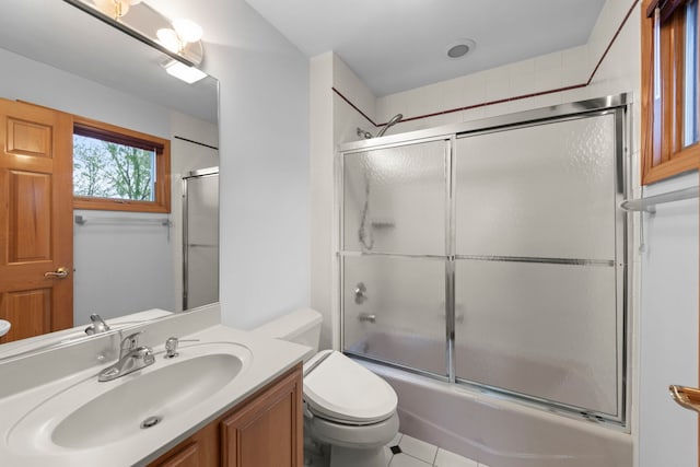 bathroom featuring vanity, toilet, tile patterned flooring, and enclosed tub / shower combo