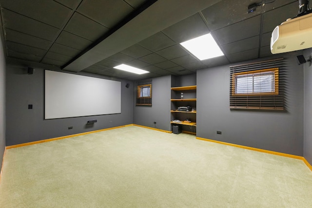 home theater with carpet flooring, a drop ceiling, and baseboards