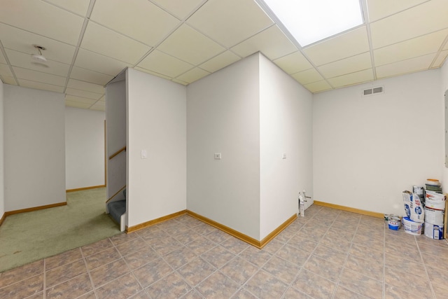 below grade area featuring stairs, baseboards, visible vents, and a drop ceiling